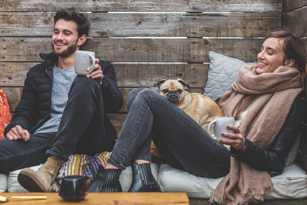 merry christmas, man, woman, dog, pet, pug, owners, couple, relationship, warm clothes, cozy, scarf, jackets, jeans, boots, fashion, people, happy, love, female, young, male, adult, caucasian, animal, happiness, romantic, portrait, smile, smiling, girlfriend, date, boyfriend, together, person, lovers, sitting, relaxing, rustic, cushions, couch, laughing, enjoying, coffee